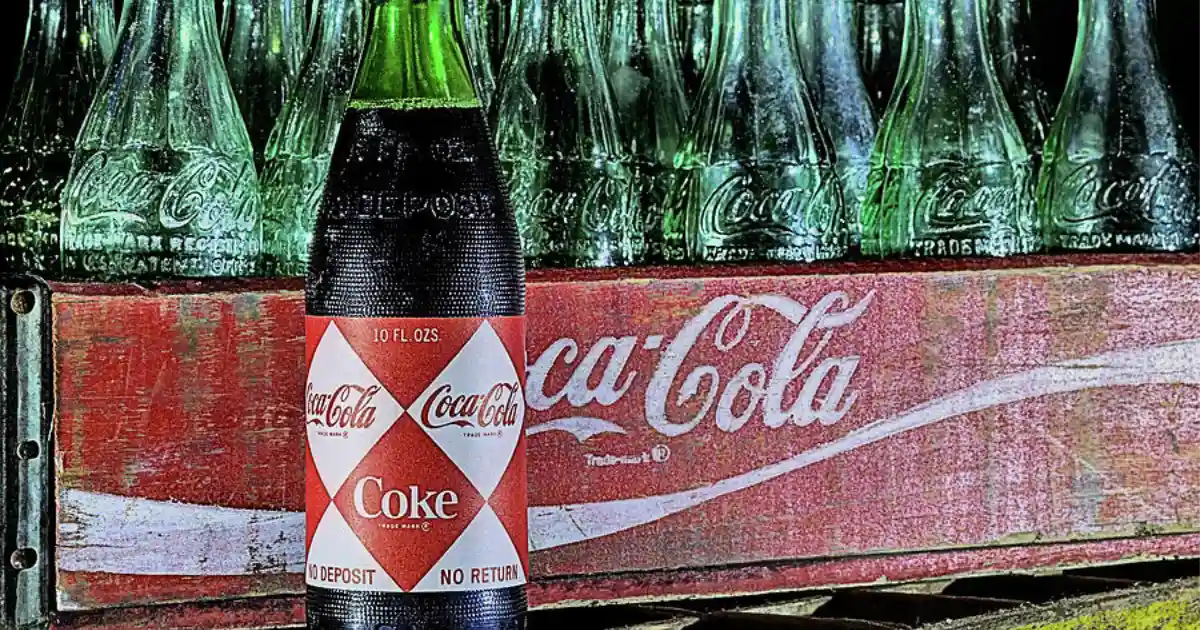 The Coca-Cola Company 1960s Coca-Cola bottle with red diamond Coke label in front of a wooden crate