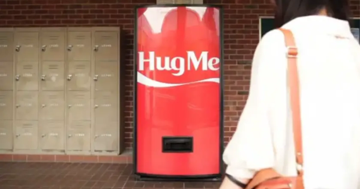 Coca-Cola Hug Me vending machine in a hallway beside lockers