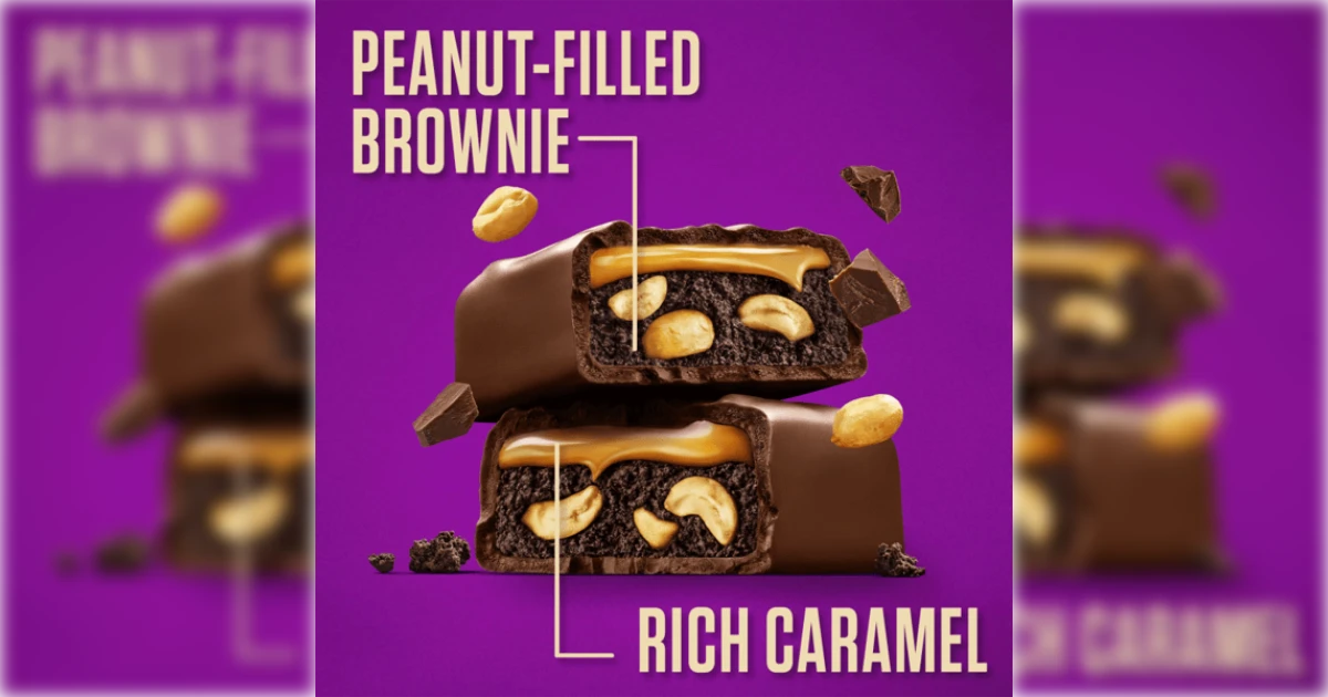 Stacked Snickers peanut brownie halves showing caramel and peanuts