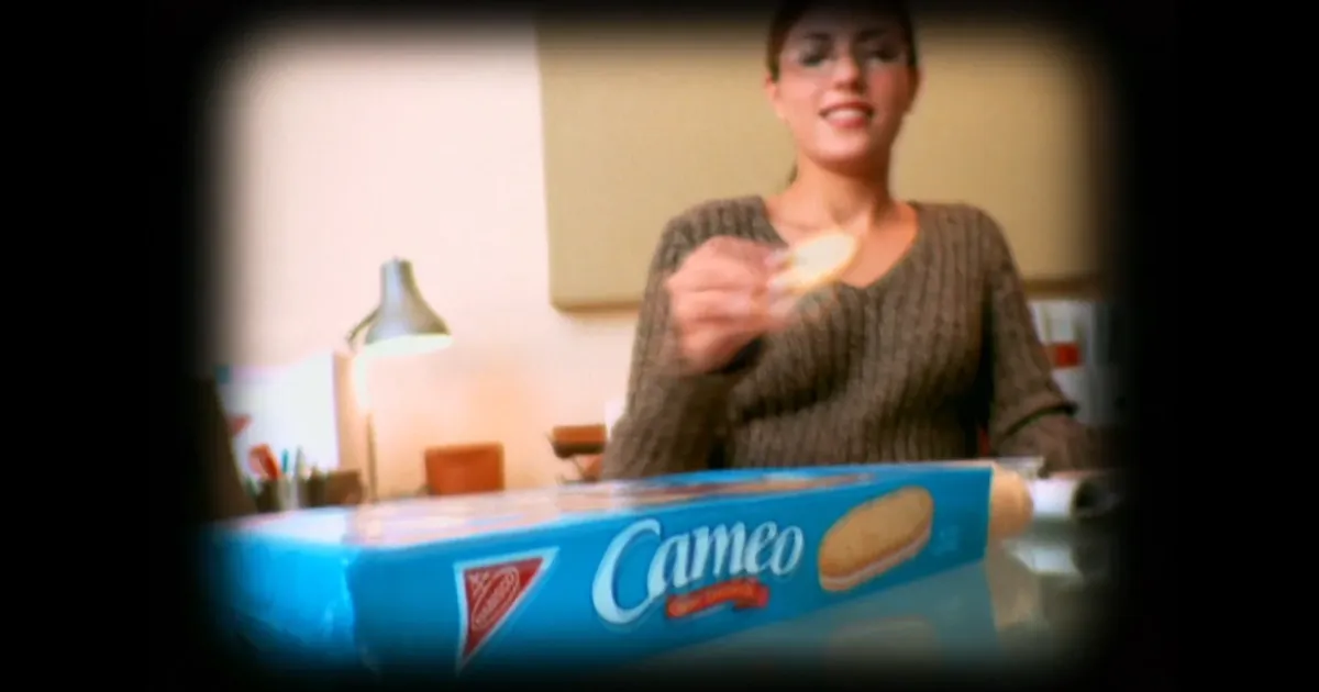 Nabisco Woman eating a Cameo cookie beside a blue Nabisco Cameo box