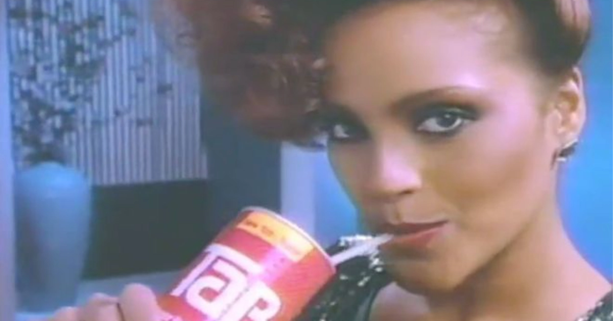 Woman sipping from a red Tab cola can in a 1980s commercial