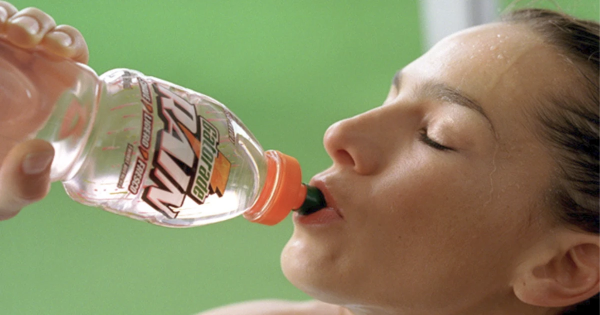 PepsiCo Woman drinking clear Gatorade Rain from a bottle with orange cap