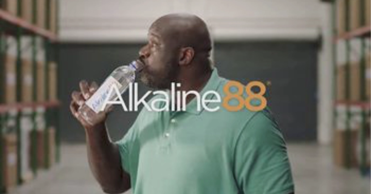 The Alkaline Water Company Shaquille O’Neal drinking from an Alkaline88 water bottle in a warehouse