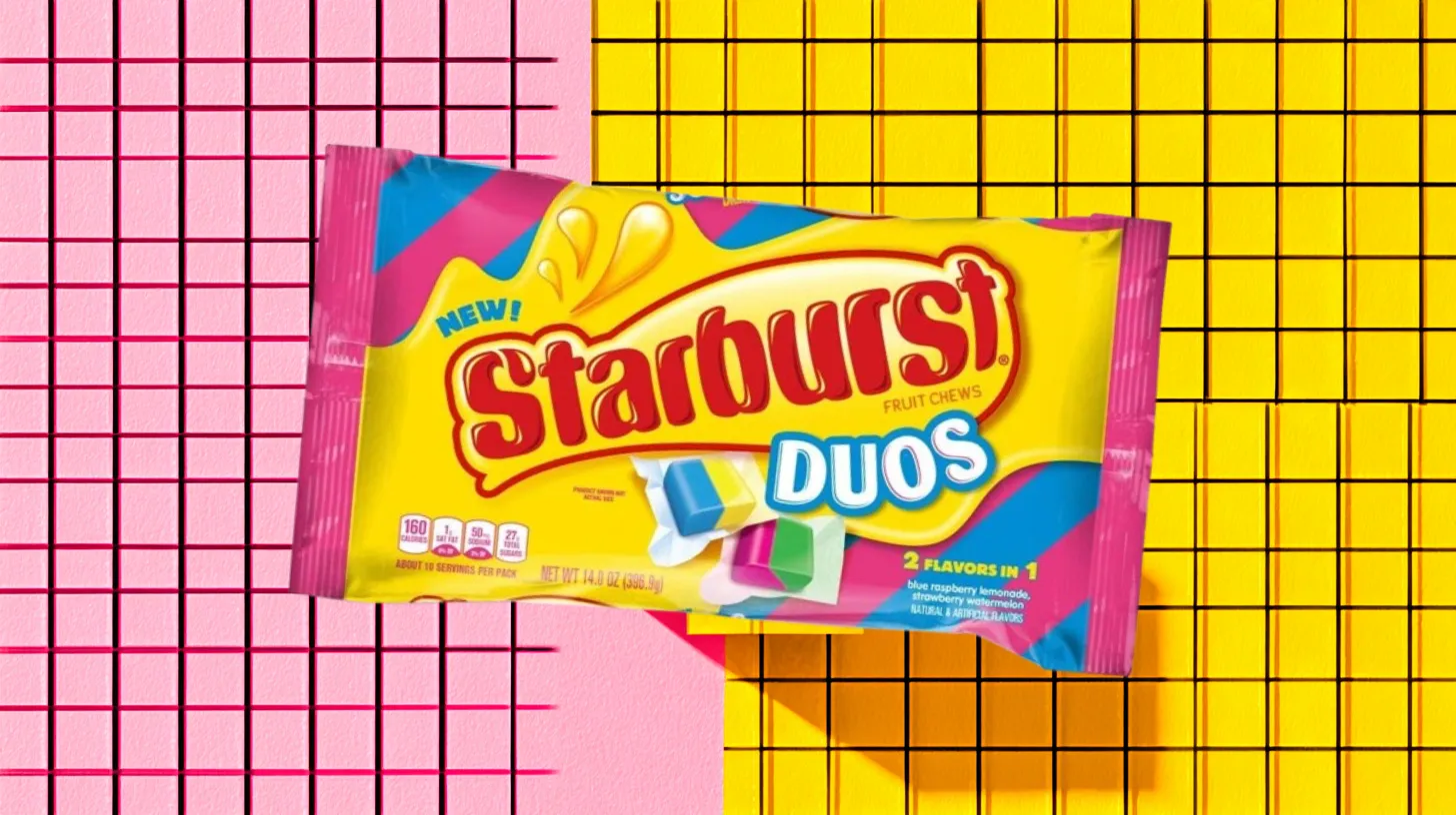 Mars, Inc. Yellow Starburst Duos fruit chews bag on pink grid background