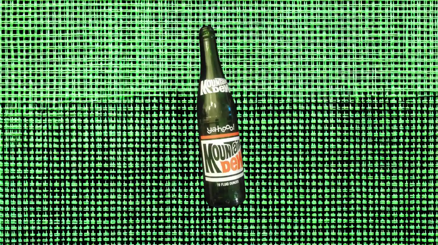 PepsiCo Green Mountain Dew bottle, 10-ounce "ya-hooo!" label, on green mesh