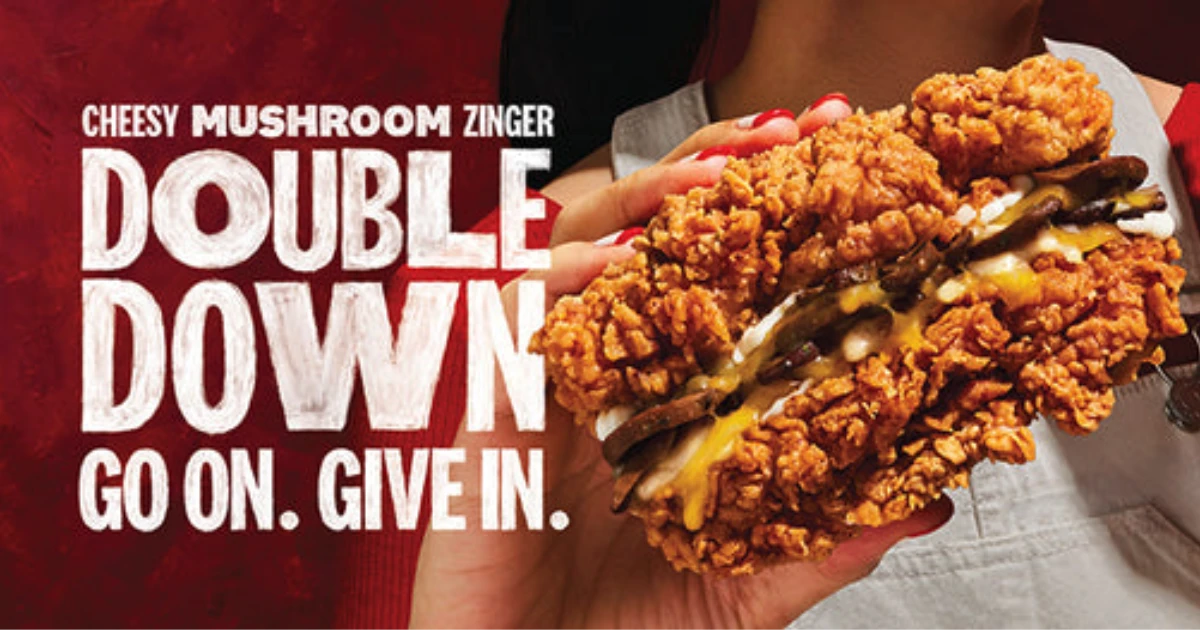 Hands holding a KFC Cheesy Mushroom Zinger Double Down sandwich
