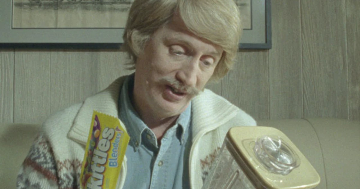 Mars, Inc Skittles Blenders commercial still with mustached man holding the yellow candy pack