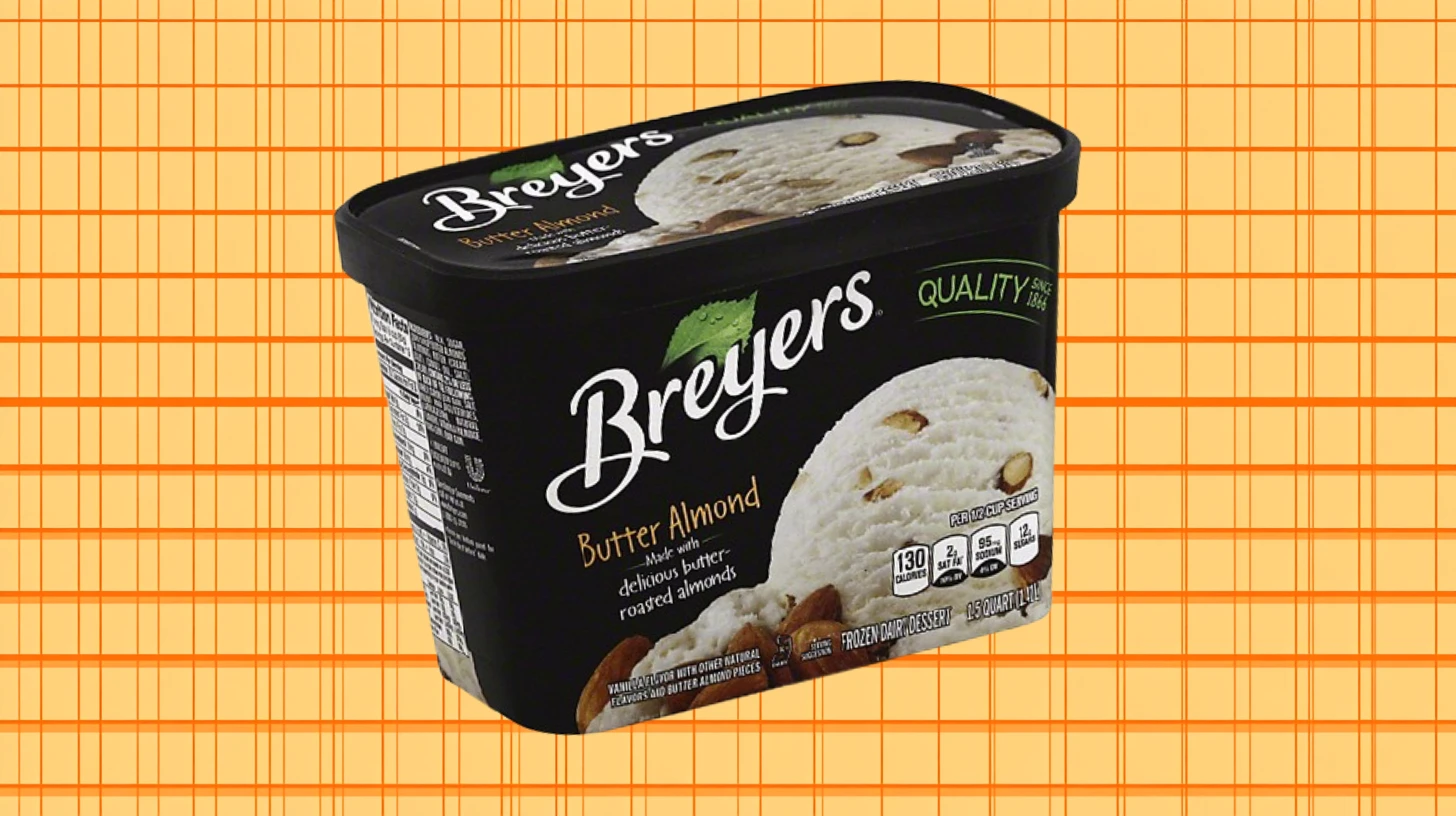 Black Breyers Butter Almond ice cream carton on orange grid background