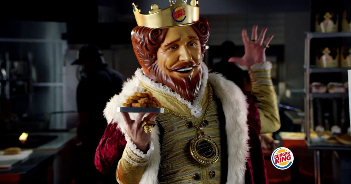 The plastic-faced Burger King, retired in March 2026 — Burger King The live-action Burger King mascot in crown and red robe holding a burger behind the counter