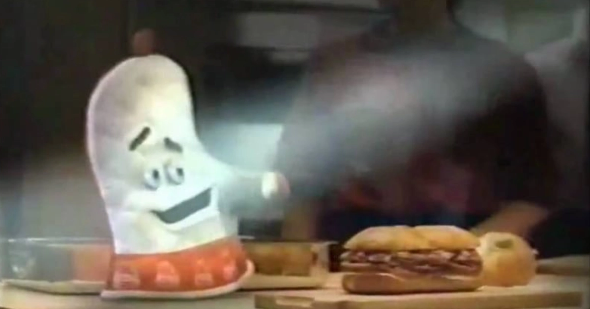 The Oven Mitt, voiced by Tom Arnold, in an Arby's commercial — Arby's The Arby's Oven Mitt mascot, a red-and-white kitchen mitt with a face, beside a roast beef sandwich