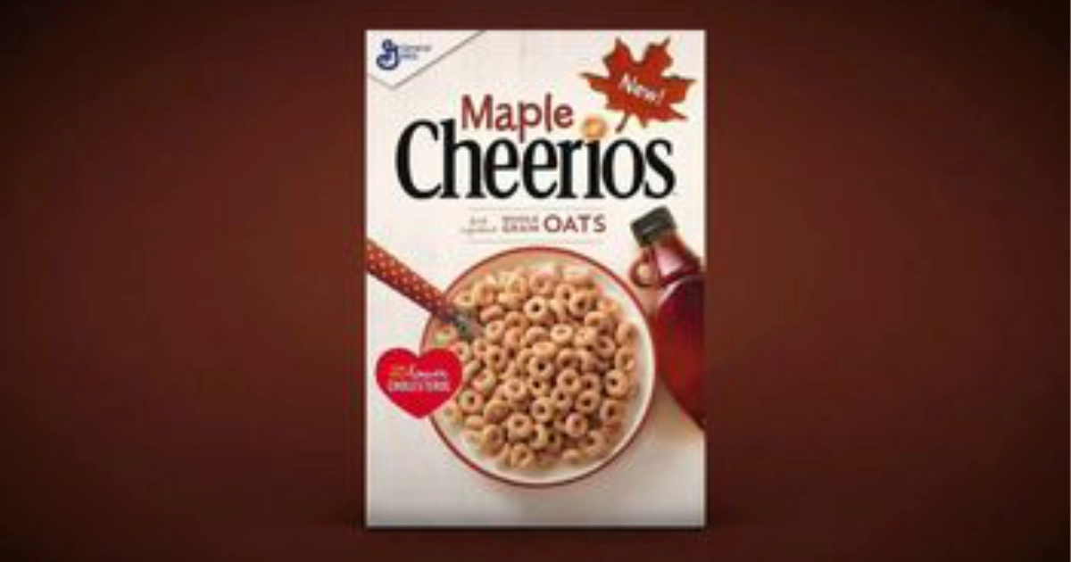General Mills Maple Cheerios box with cereal bowl and syrup bottle on brown background