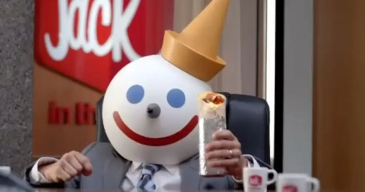 The end of the Sittig era — Jack in the Box Jack Box mascot holding a burrito beside company sign