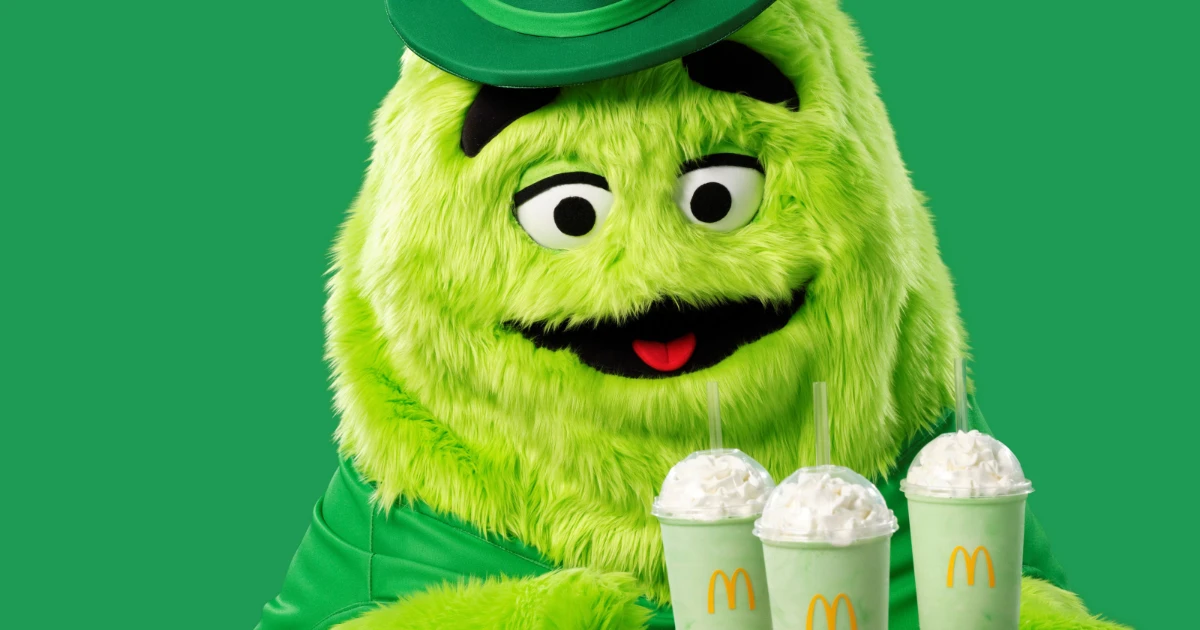 Uncle O'Grimacey, the green Grimace mascot in an Irish hat, with Shamrock Shakes