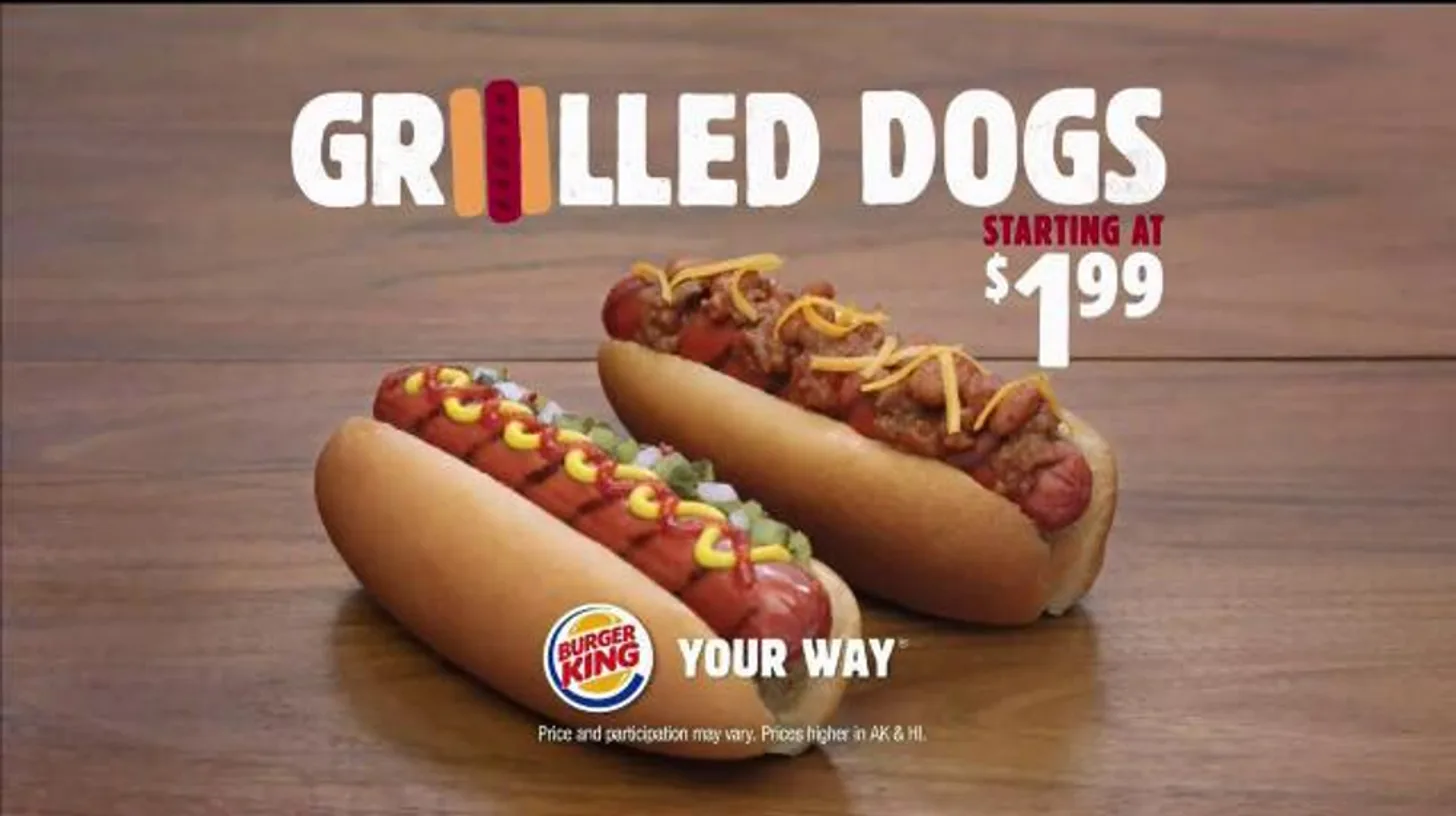 The 2016 Grilled Dogs launch ad — classic and chili cheese, starting at $1.99 — Burger King Burger King Grilled Dogs ad showing a classic mustard-and-ketchup hot dog beside a chili cheese dog, starting at $1.99