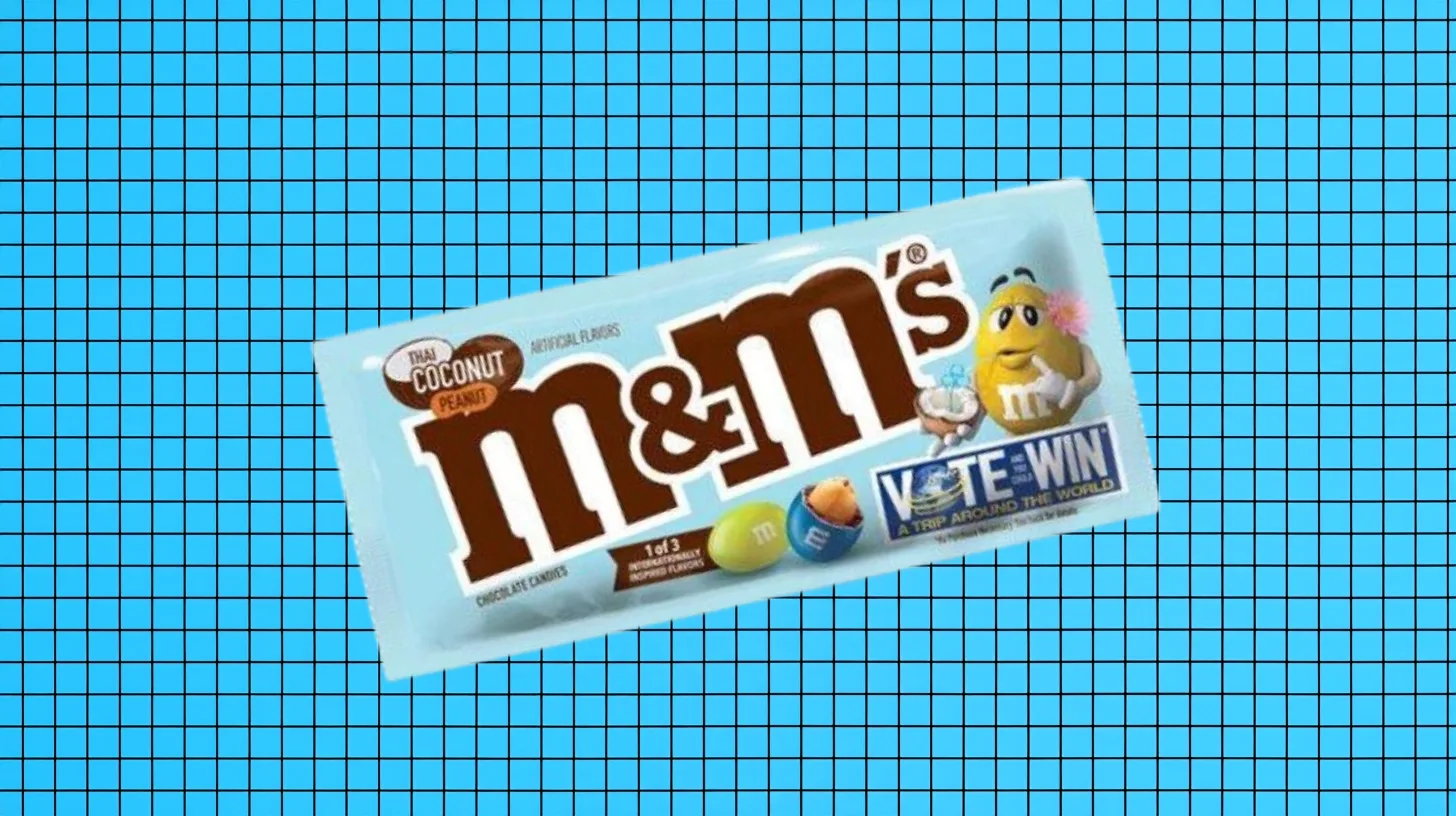 Thai Coconut Peanut M&M’s, one of three 2019 Flavor Vote finalists — Mars, Inc. Light blue bag of Thai Coconut Peanut M&M’s with the yellow M&M holding half a coconut and a Vote and Win badge
